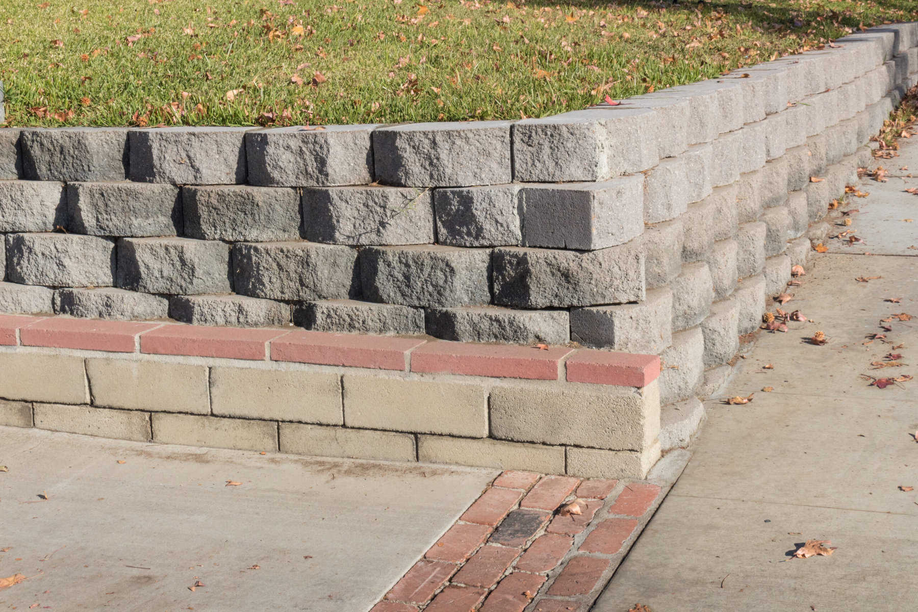 Residential retaining wall featuring a variety of stacked blocks and mortared brick textures, horizontal aspect retaining wall jupiter fl